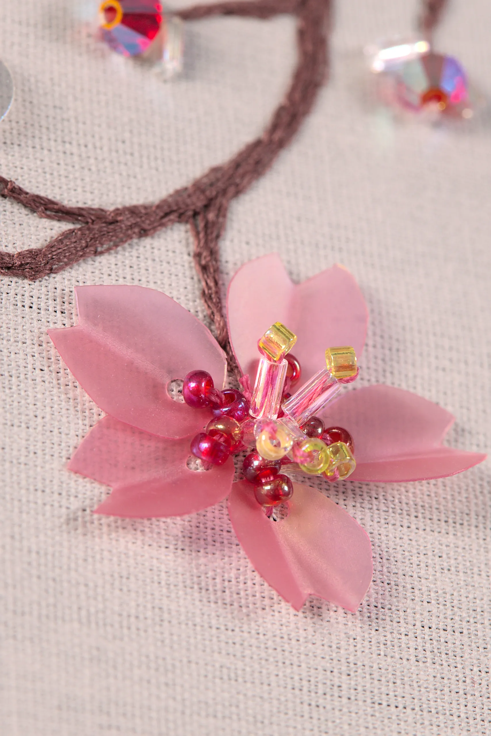 Macrofotografía de una flor de sakura bordada, que muestra con asombroso detalle las delicadas técnicas de bordado de la Alta Costura.