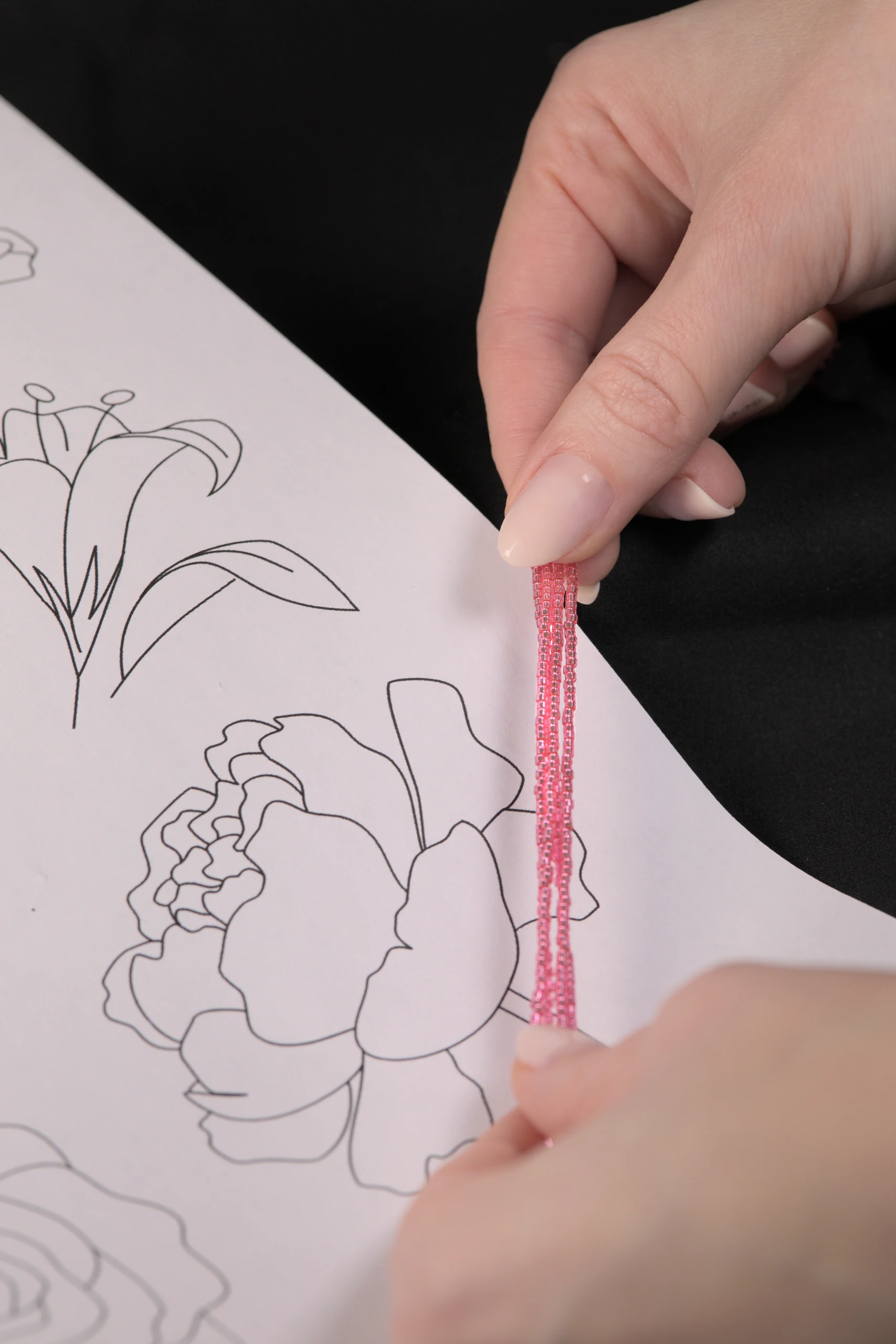 Printed floral embroidery design with pink crystal beads, illustrating the challenge of selecting the right materials for a custom embroidery project.
