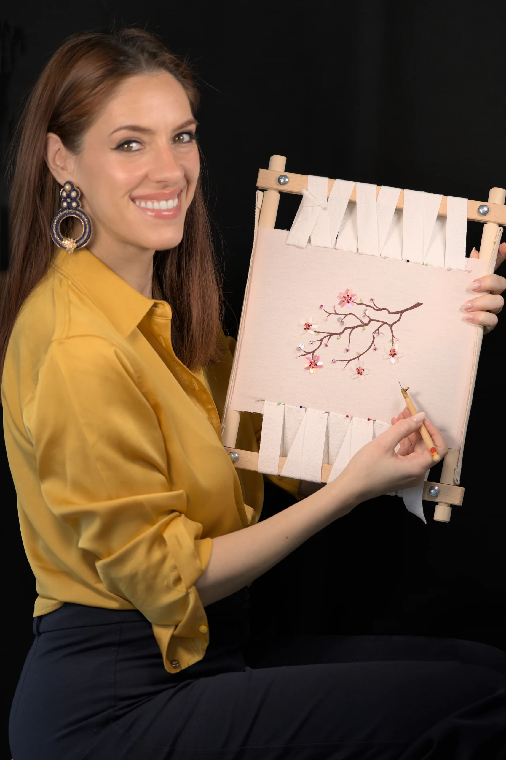 Laura S. Urbina presenta un bastidor de bordado con flores de cerezo, mostrando videotutoriales de bordado de Alta Costura con guía paso a paso.