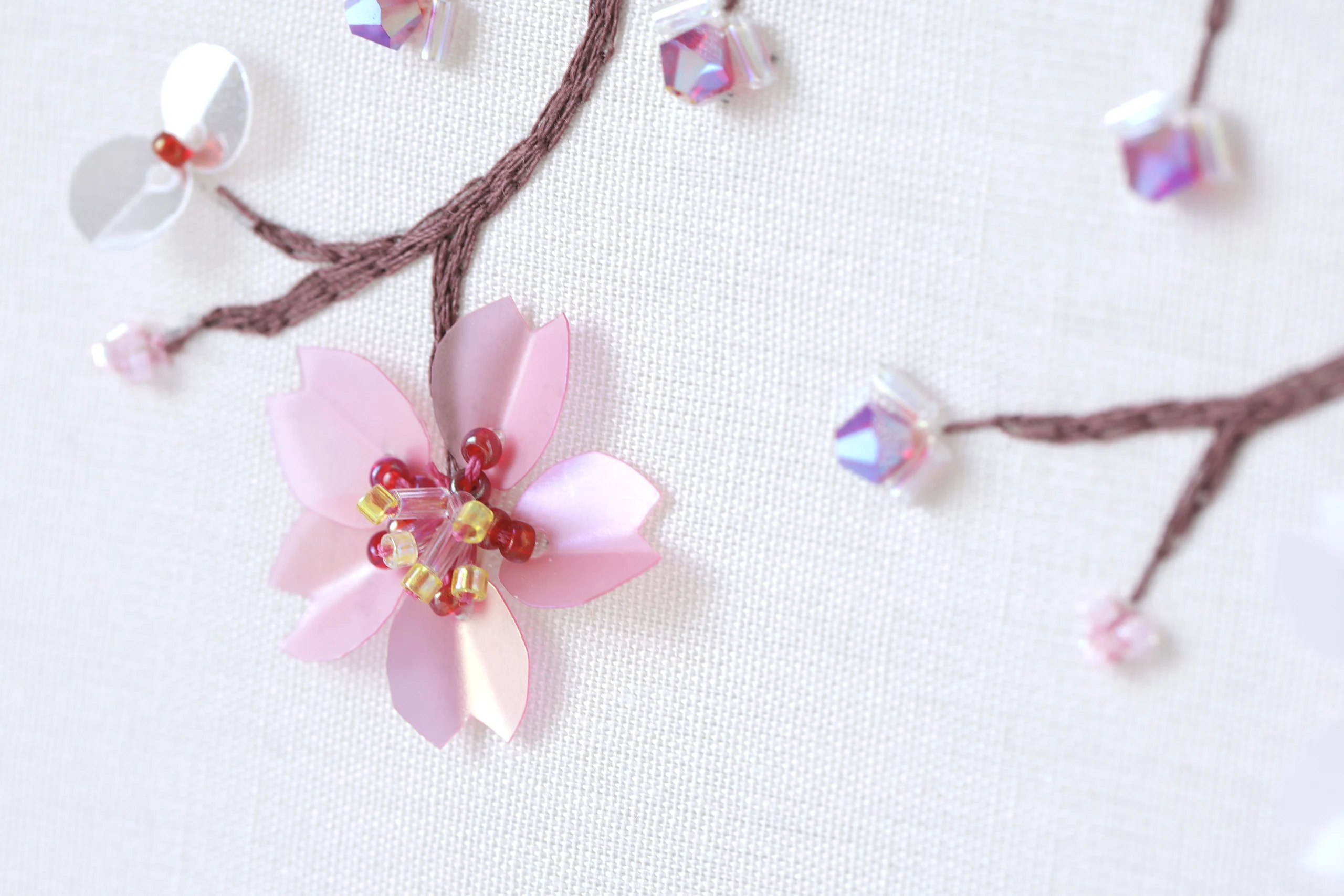 Bordado de flores de cerezo sobre bastidor, ejemplo de las técnicas de alta costura que se aprenden en los video tutoriales de Delta V Creations.