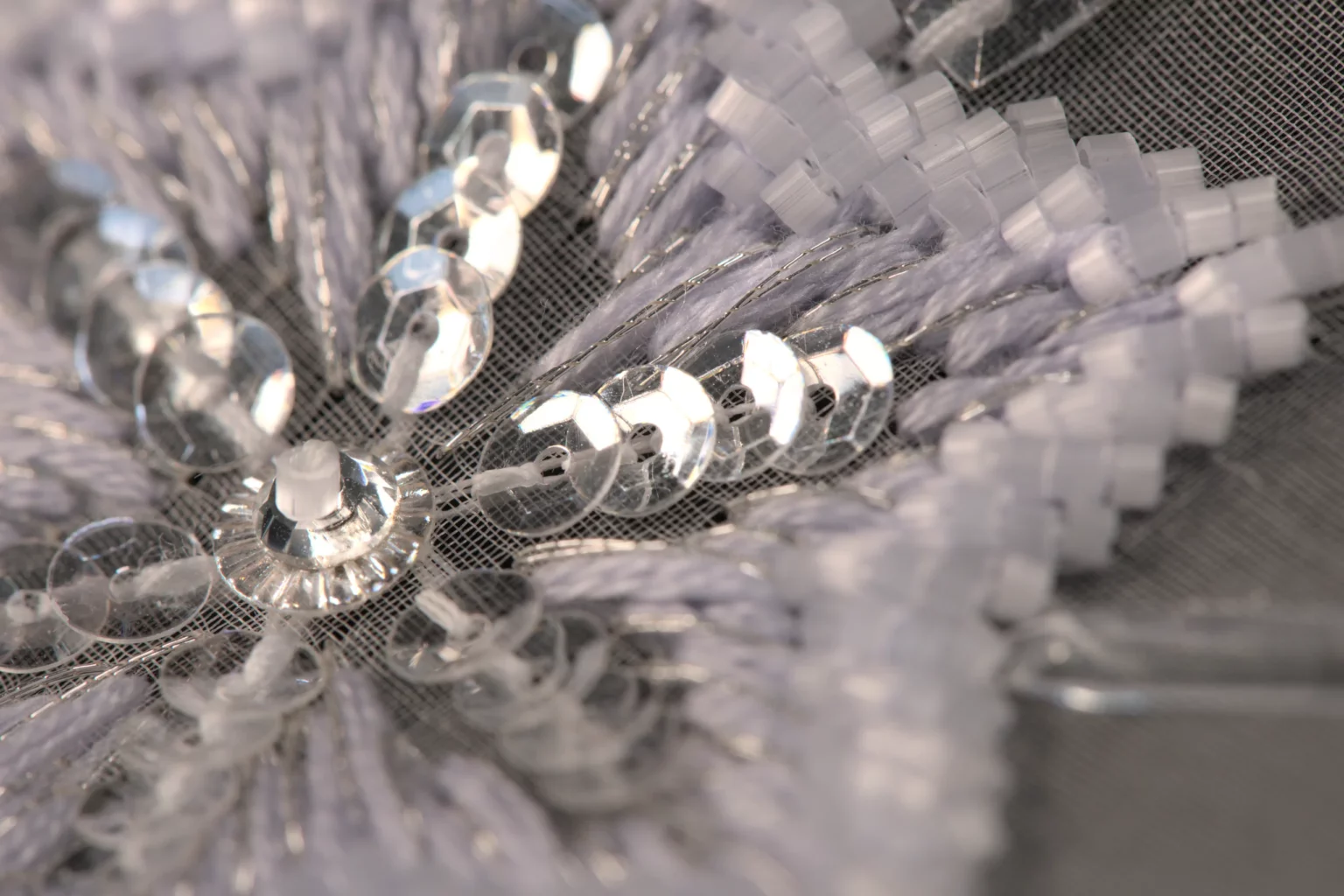Macro shot of a refined snowflake embroidery pattern, showcasing delicate beadwork and Haute Couture craftsmanship.