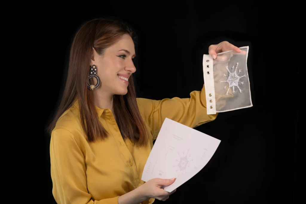 Laura S. Urbina présente un motif de broderie sur papier ainsi que son échantillon brodé, mettant en valeur ses motifs de broderie haute couture exclusifs.