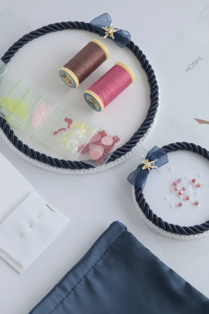 Vue à plat du kit Hoshi avec fils de broderie haute couture, perles et sequins pour créer des fleurs de cerisier en 3D.